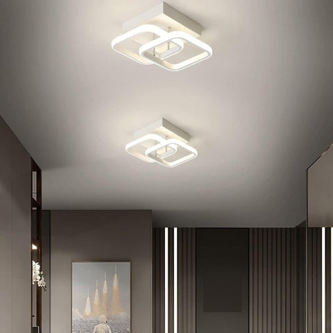 Two modern square ceiling lights on a ceiling with a neutral color scheme.