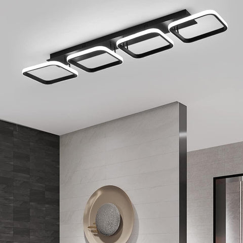 Modern ceiling light fixture in a room with a mirror and wall decor.
