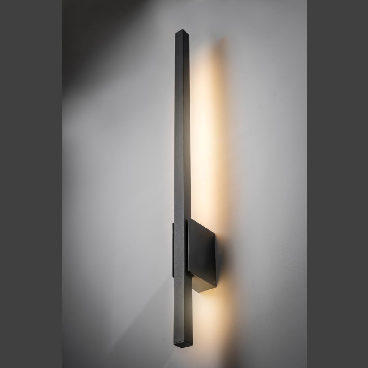 Modern wall-mounted light fixture on a gray wall