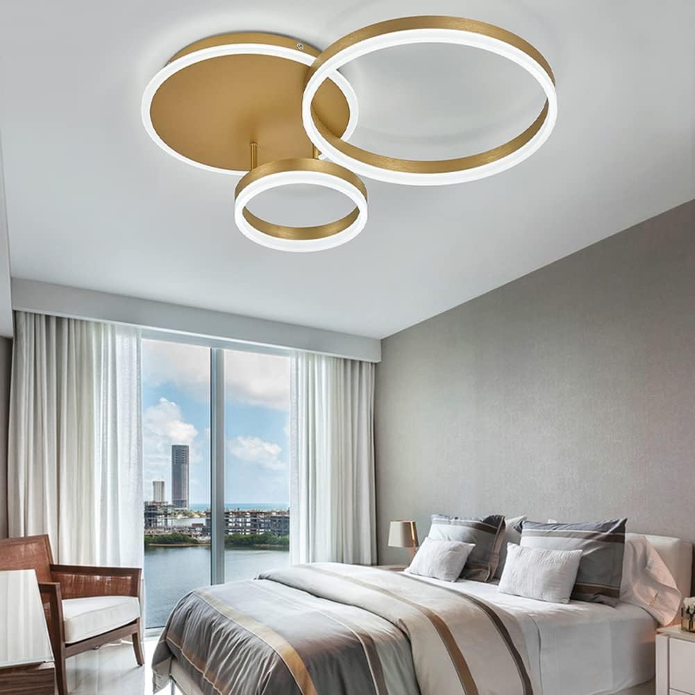 Modern ceiling light fixture in a bedroom with a bed and window view.