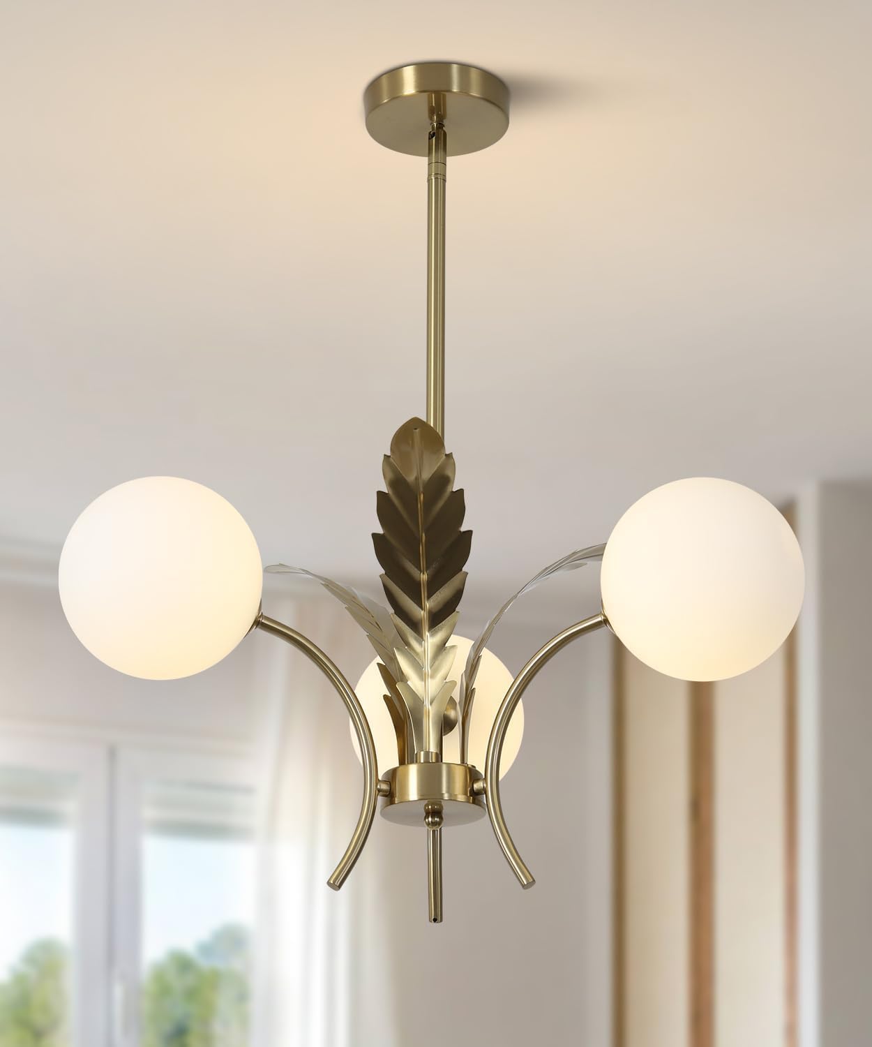 Modern chandelier with gold leaf design and two white glass shades on a neutral background.