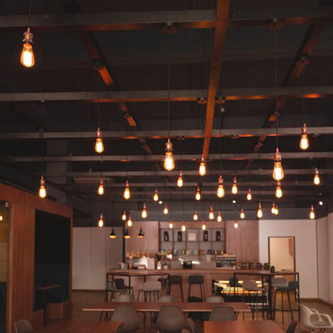 Modern interior with hanging light bulbs and a bar area.