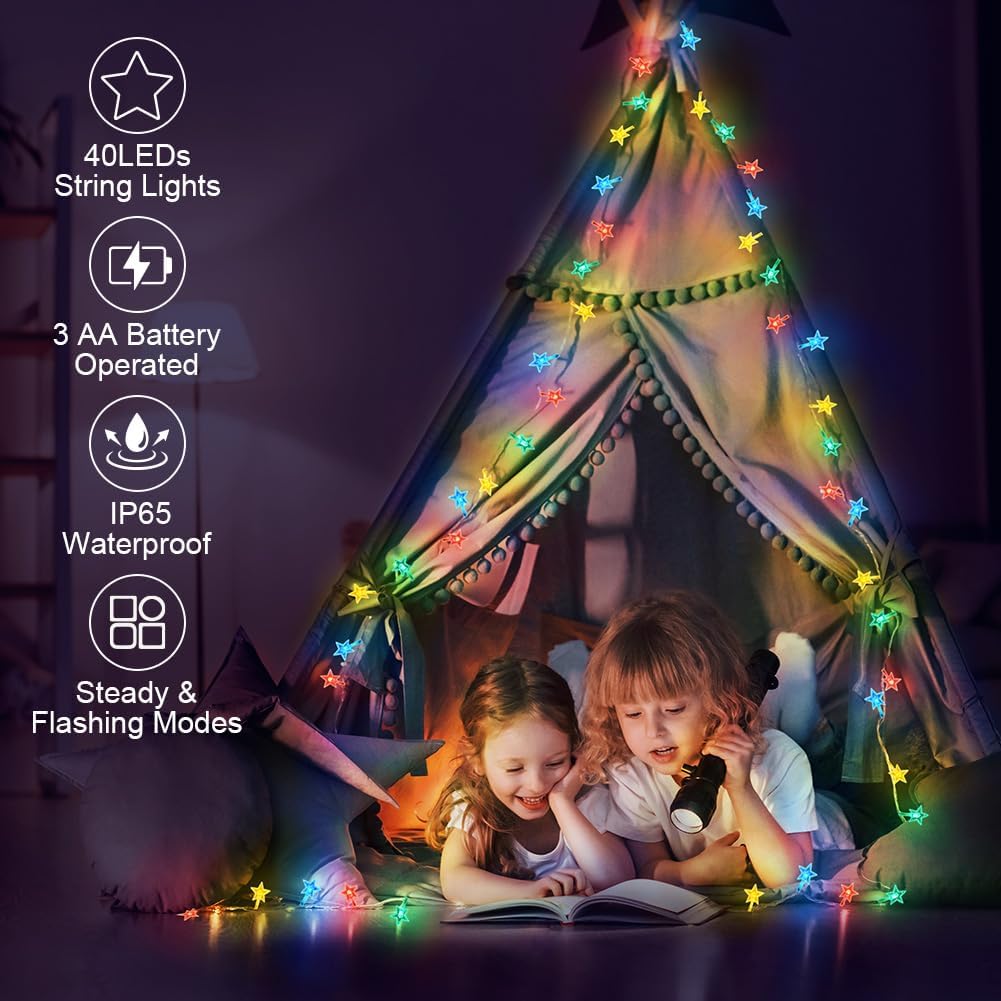 Children reading under a teepee with colorful string lights inside a dark room.