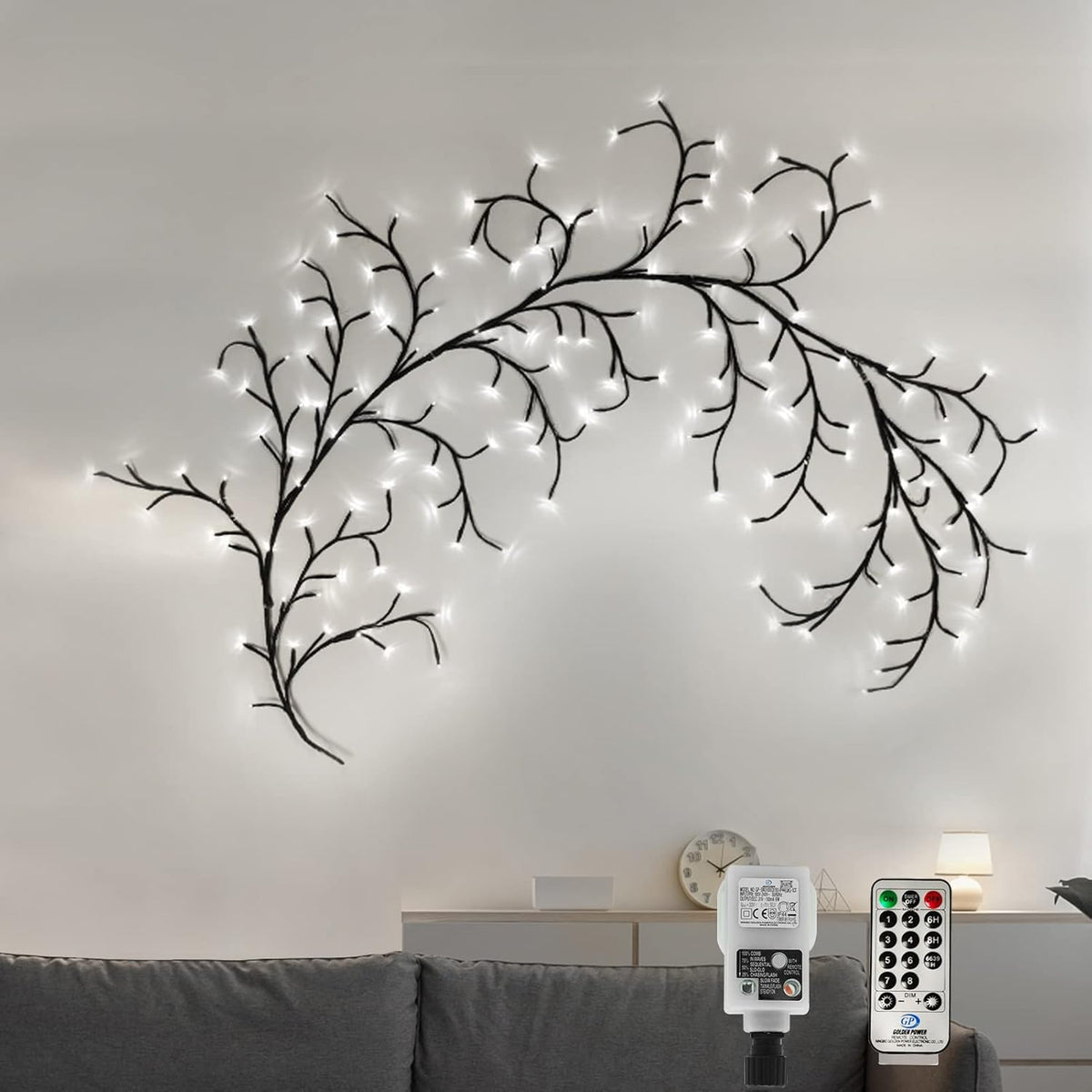 Decorative wall light fixture shaped like branches with lights on a plain wall.