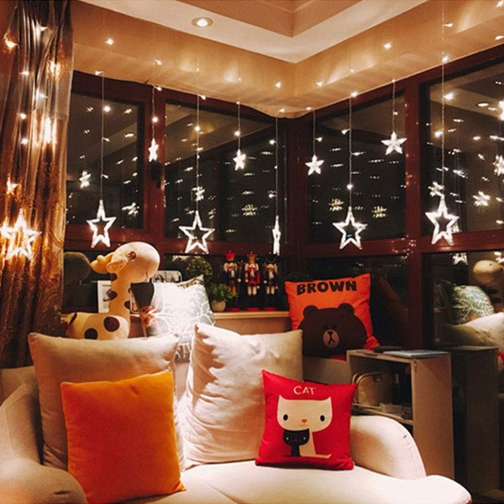 Decorative indoor setting with star-shaped lights, pillows, and a teddy bear.