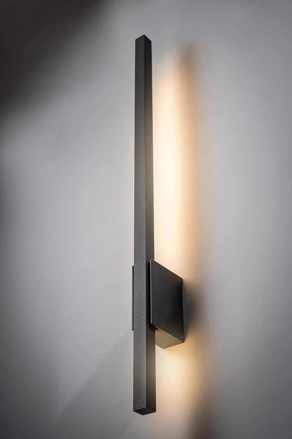 Modern wall-mounted light fixture on a gray wall