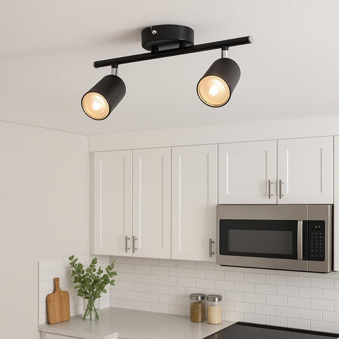 Black ceiling light fixture in a kitchen with white cabinets and a microwave.