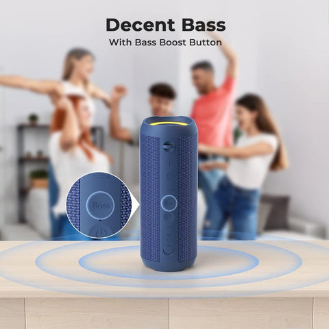 Blue portable speaker with bass boost button on a wooden surface, people dancing in the background.