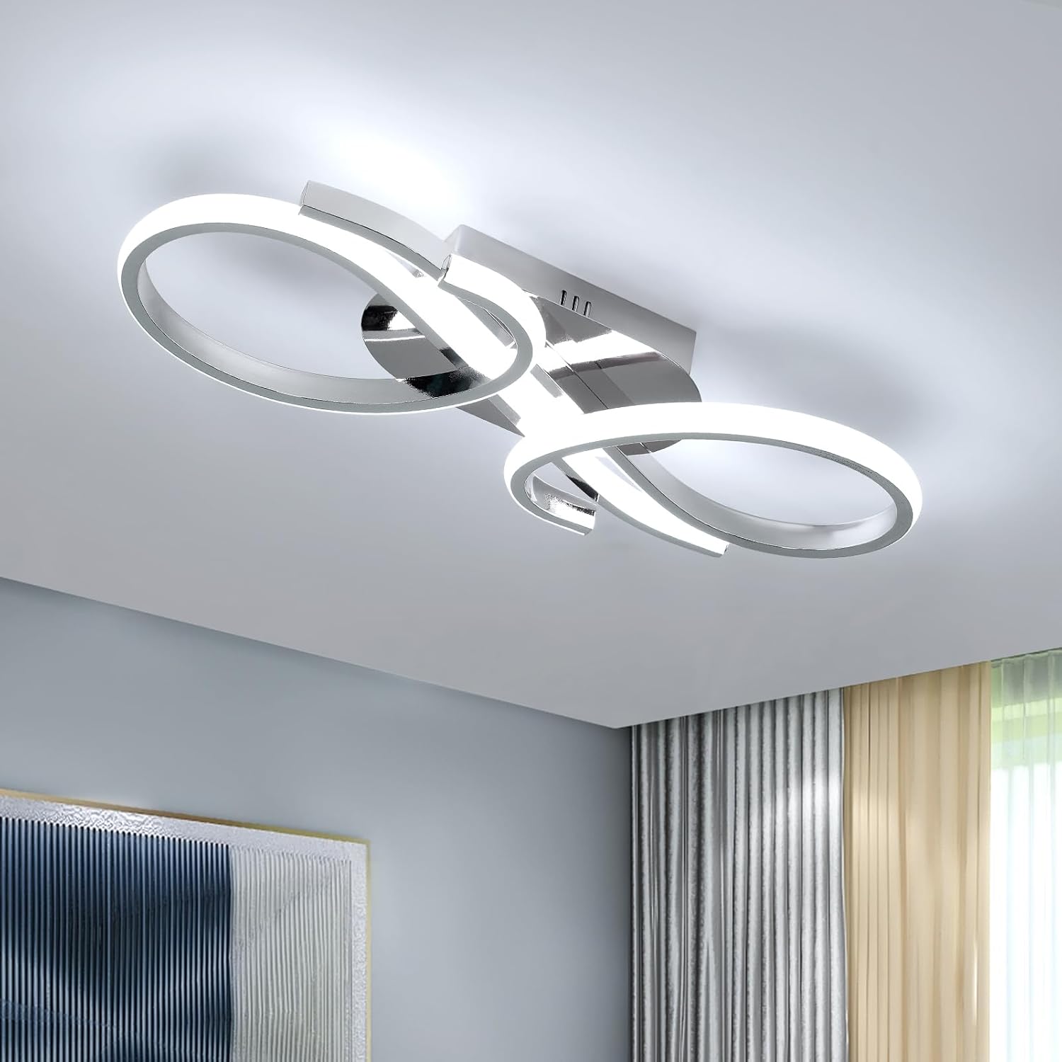 Modern ceiling light fixture with circular design in a room with light blue walls and curtains.