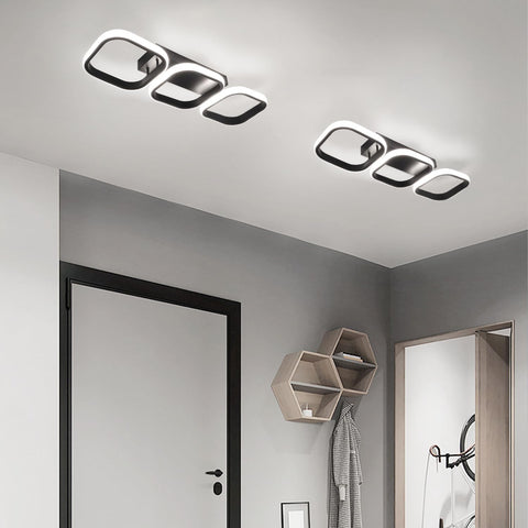 Modern ceiling lights in a room with gray walls and a door.