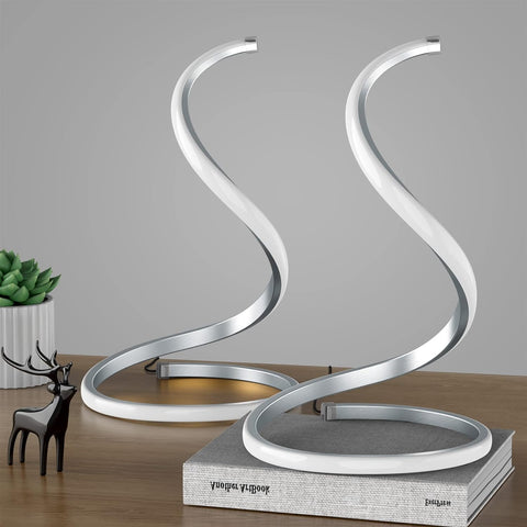 Modern decorative sculpture with a spiral design on a wooden surface.
