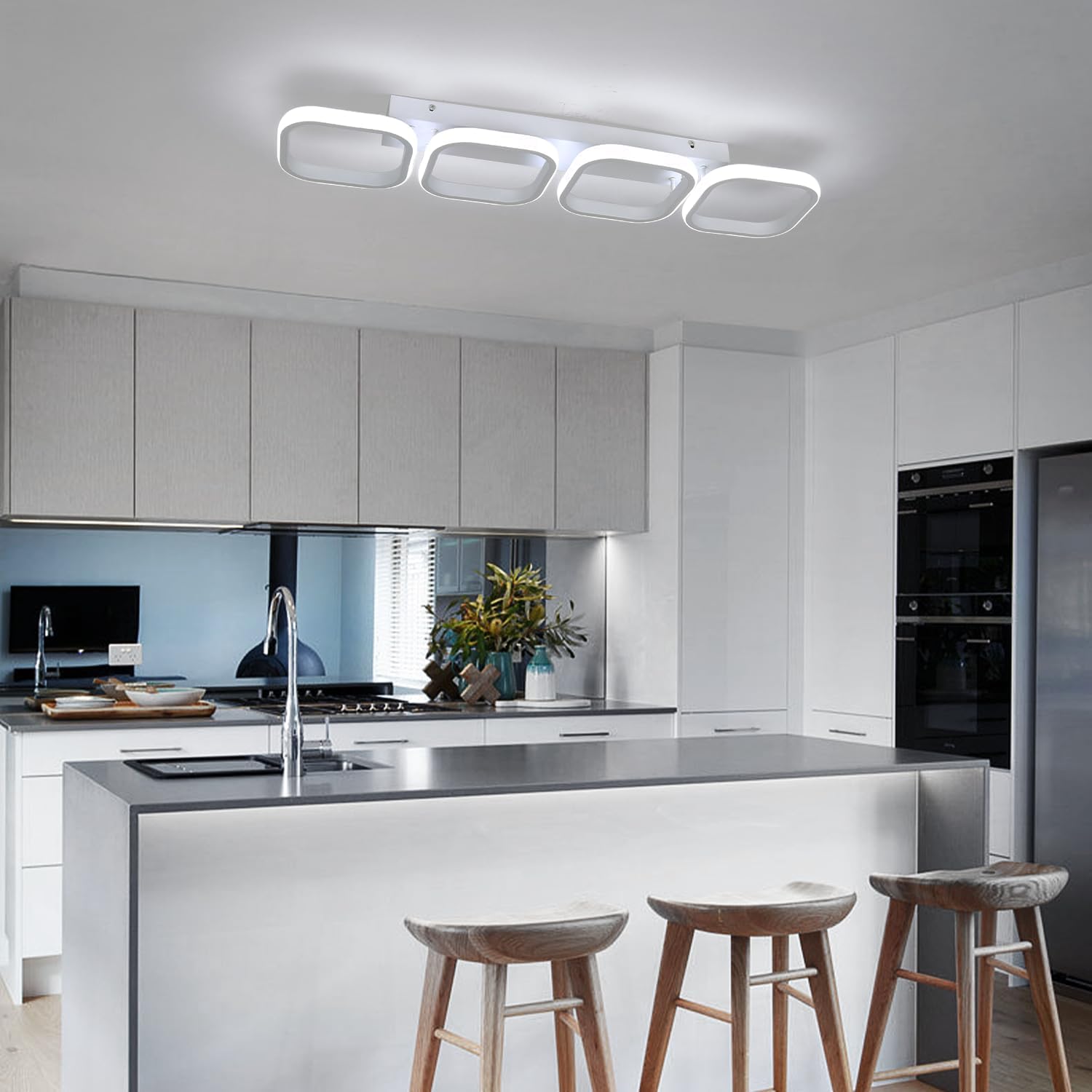 Modern kitchen with white cabinets, island, and bar stools.