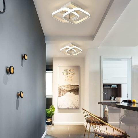 Modern interior design with ceiling lights, wall art, and a chair.