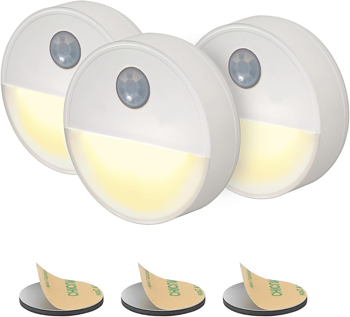 Three motion sensor lights with adhesive pads on a white background