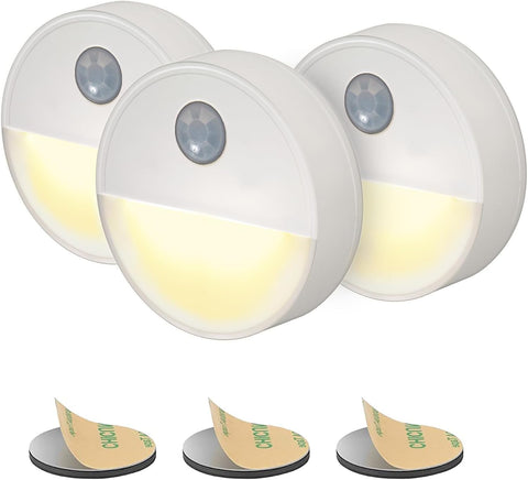 Three motion sensor lights with adhesive pads on a white background