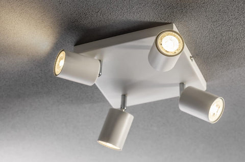 Modern ceiling light fixture with four lights on a gray ceiling.
