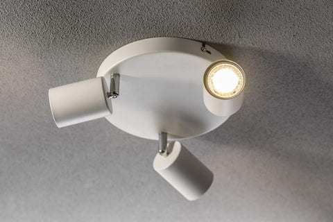 White ceiling light fixture with two adjustable arms on a gray ceiling.