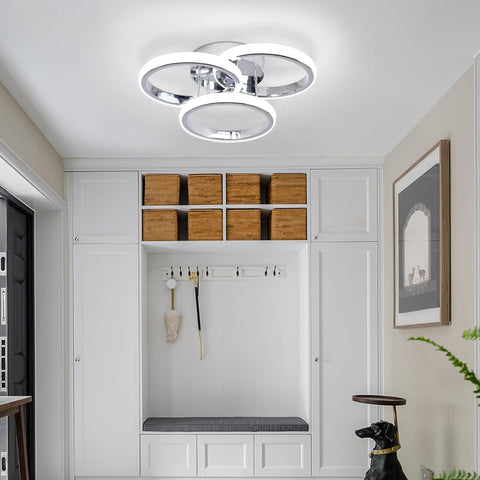 Modern hallway with white cabinets, wooden boxes, and a ceiling light fixture.