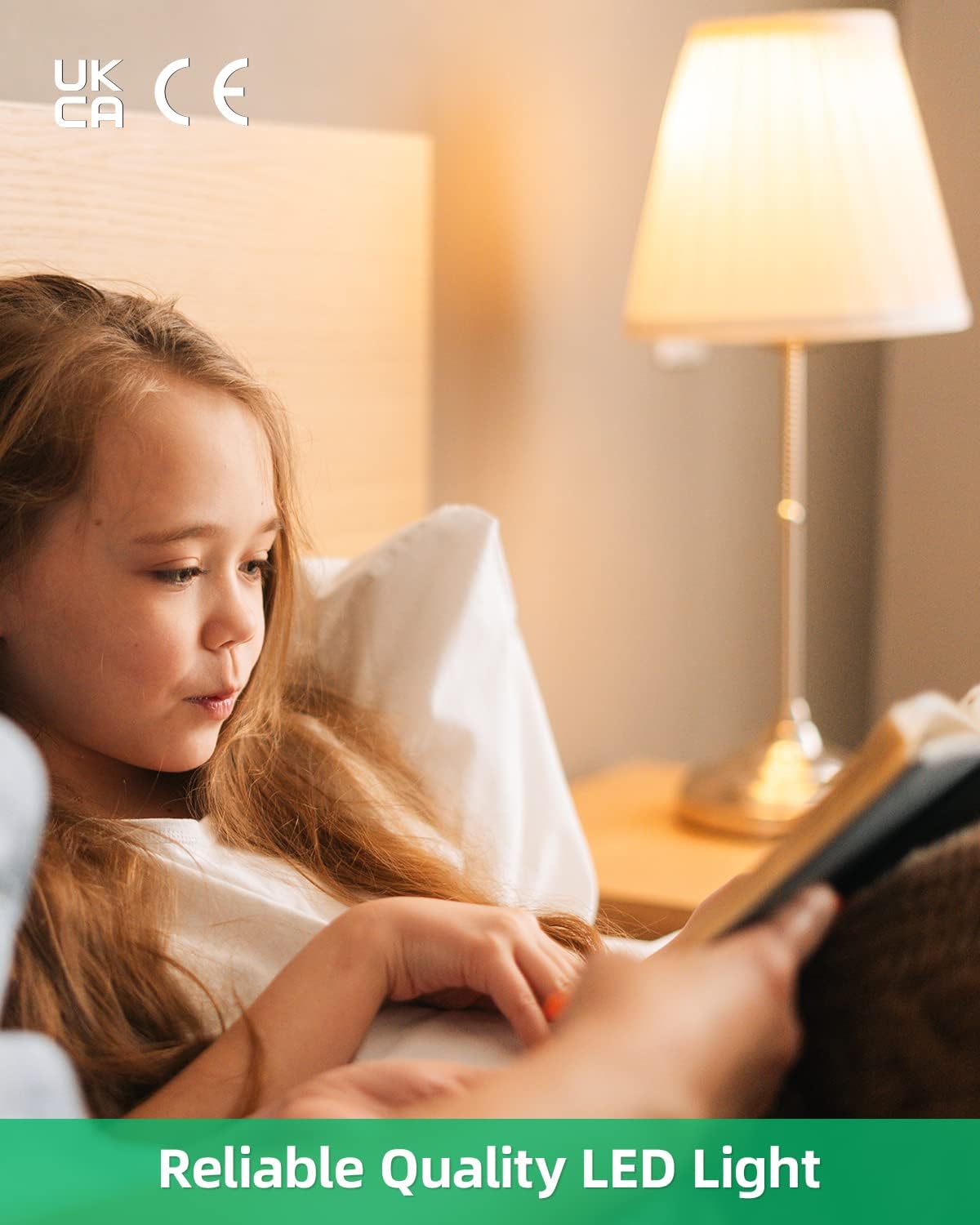 Child reading a book in bed with a lamp on a nightstand, featuring UKCA and CE logos.