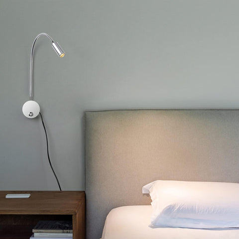 Modern wall lamp next to a bed with a neutral headboard