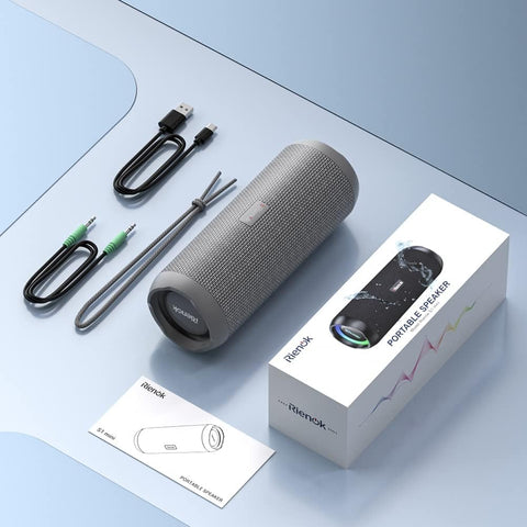 Gray portable speaker with accessories on a light blue surface