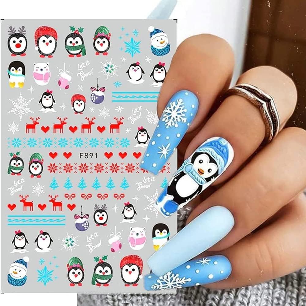 Nail art with penguin design on a light blue background, next to a sheet of nail art stickers.