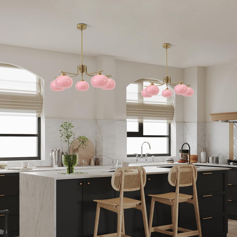 Modern kitchen with pink pendant lights and wooden stools.