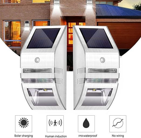 Pack of 4 LED solar security lights mounted on a fence at night

