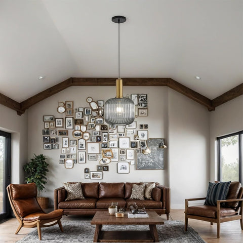 Living room with brown leather sofa, armchairs, and a wall of framed pictures.