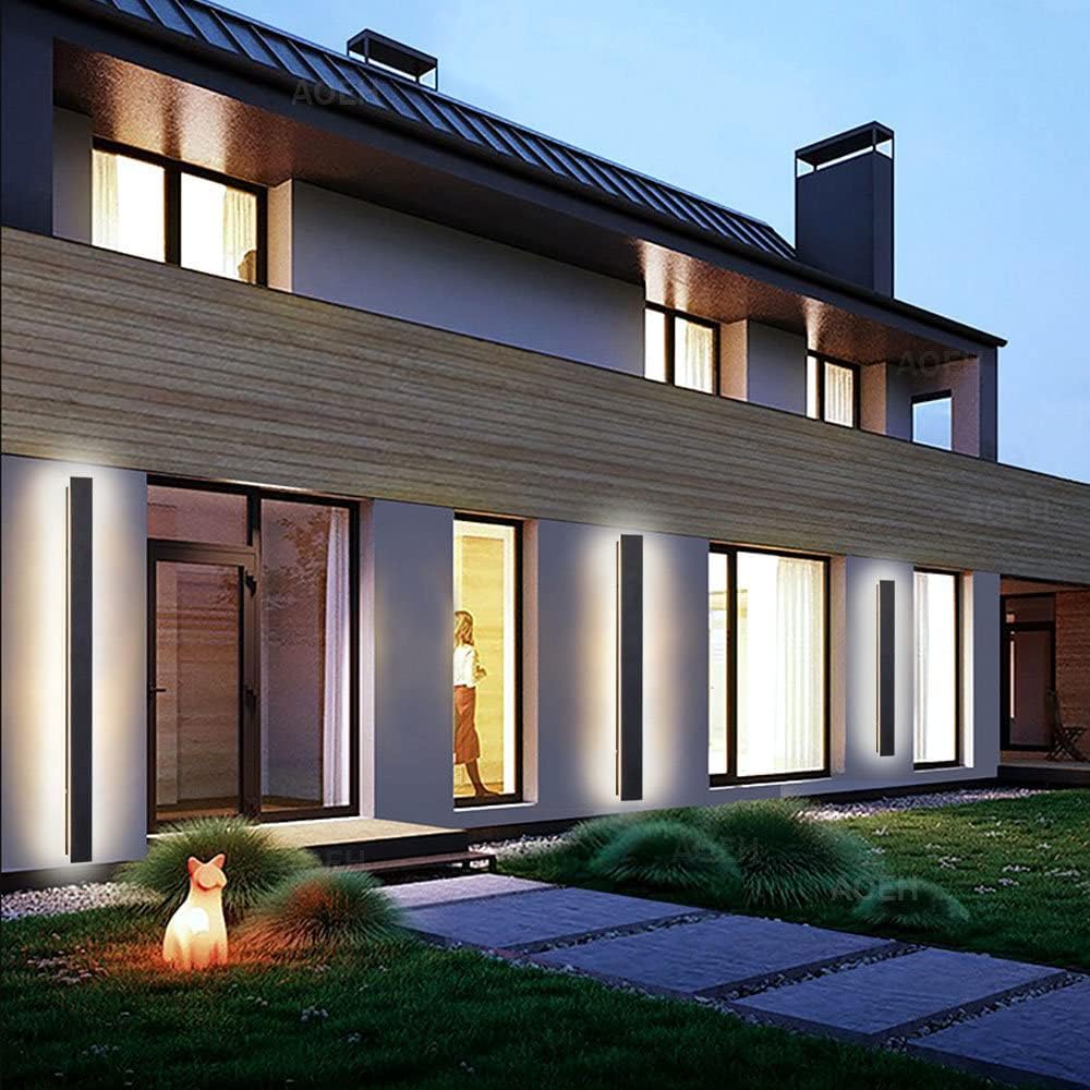 Modern house exterior with illuminated windows and a lit fox figure in the garden.