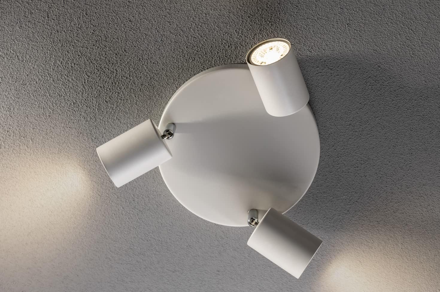 Modern ceiling light fixture with three white lampshades on a gray ceiling.