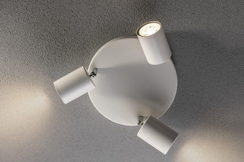 Modern ceiling light fixture with three white lampshades on a gray ceiling.