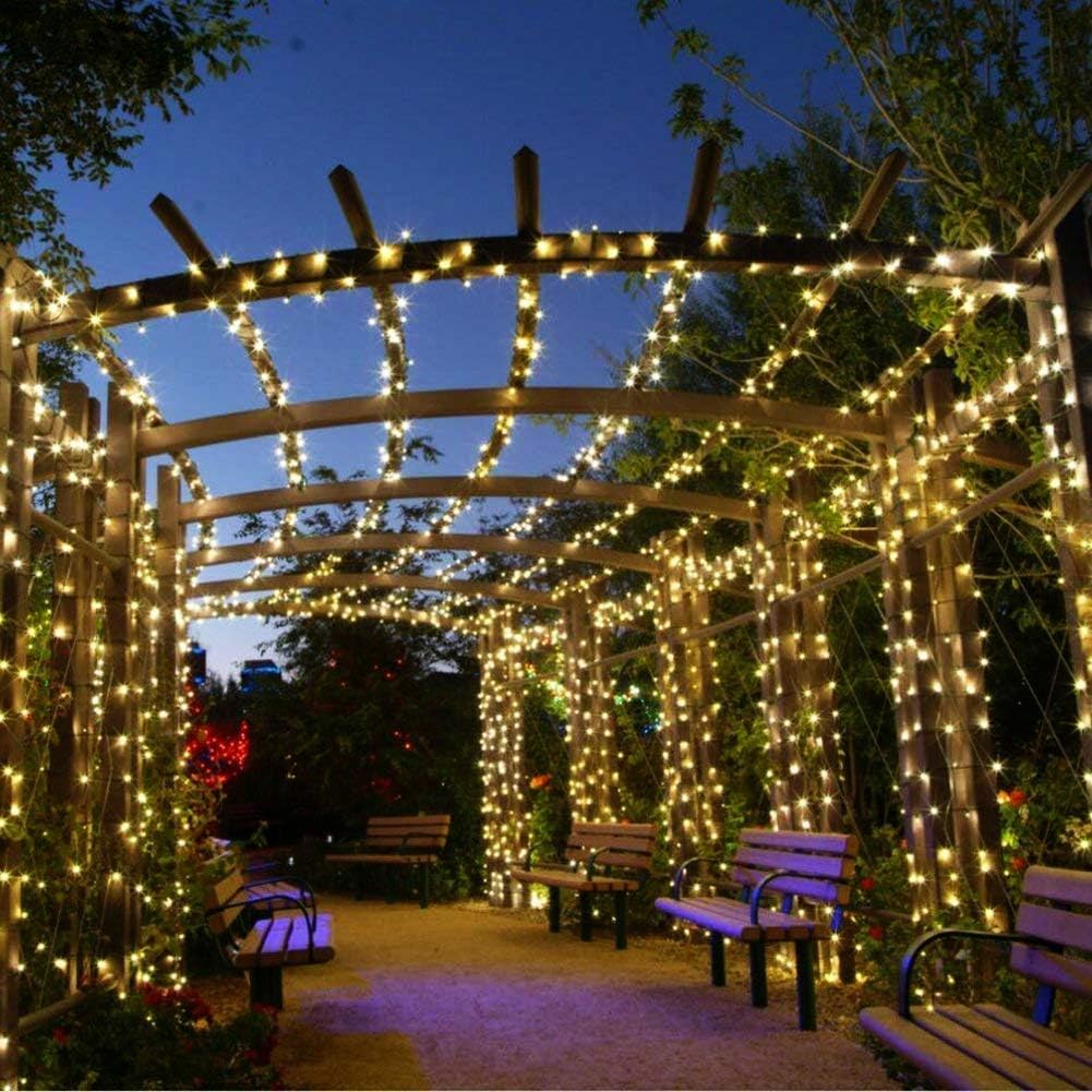 Wooden pergola with string lights in a garden setting at night