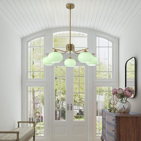 Chandelier with green glass shades in a room with large windows and a wooden cabinet.