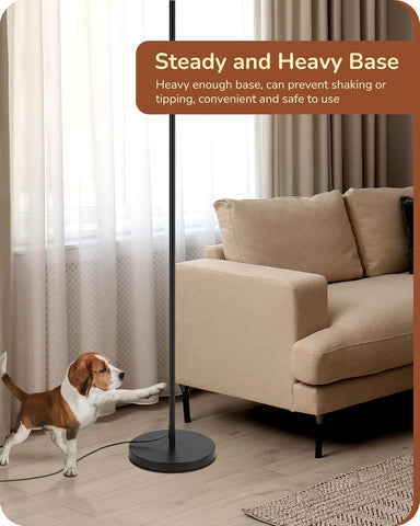 Dog playing with a lamp stand in a living room setting, emphasizing a stable base.