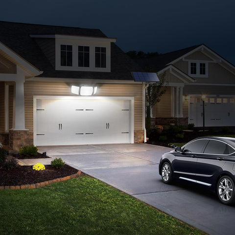 House with a garage and car parked outside at night
