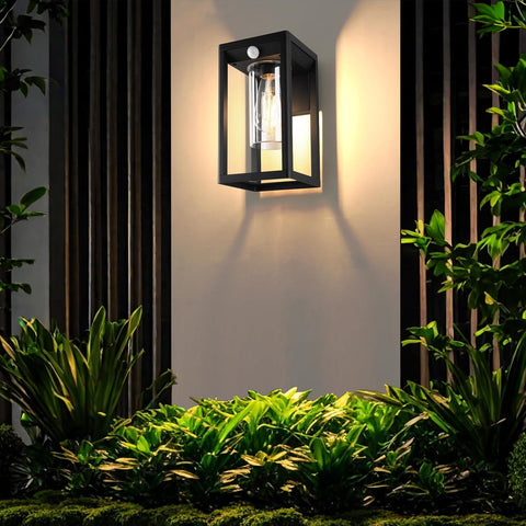 Outdoor wall light fixture on a garden wall with plants around