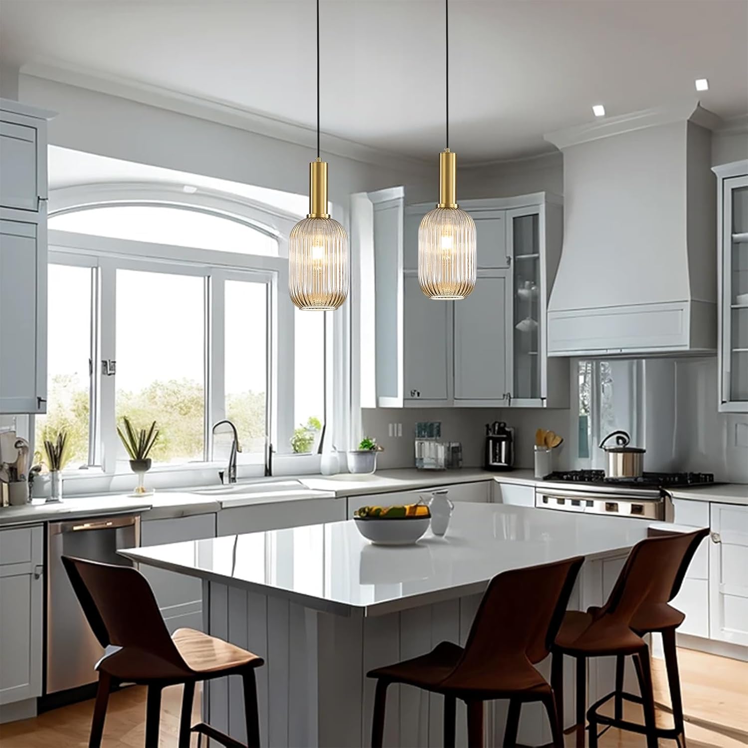 Modern kitchen with white island, pendant lights, and large windows.