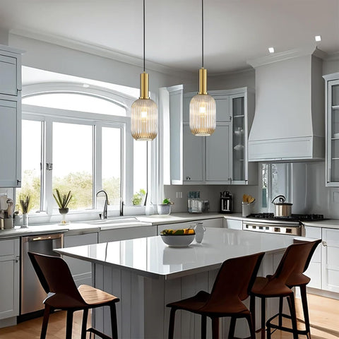 Modern kitchen with white island, pendant lights, and large windows.