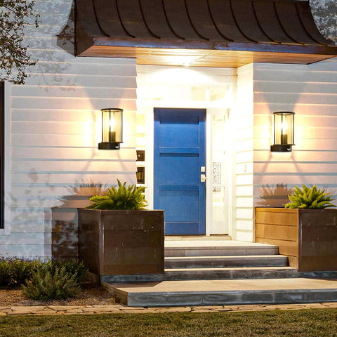 Modern house entrance with a blue door, steps, and outdoor lighting fixtures.