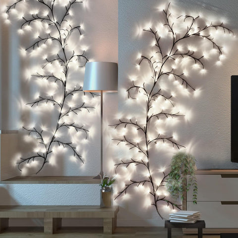 Decorative wall lights shaped like branches in a room setting with a lamp and TV.