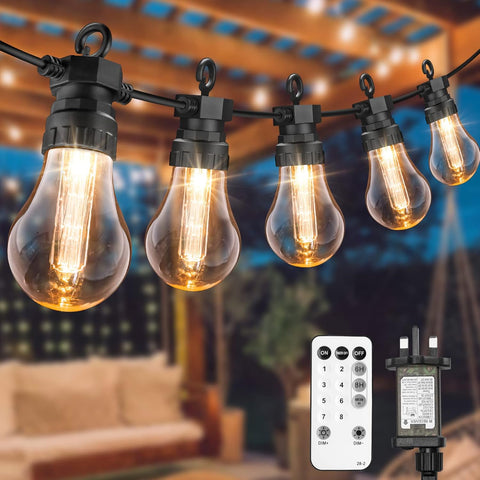 String of vintage-style light bulbs with a remote control and transformer on an outdoor setting.