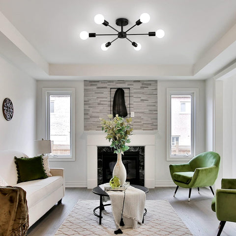 Modern living room with white sofa, green chairs, and a fireplace.