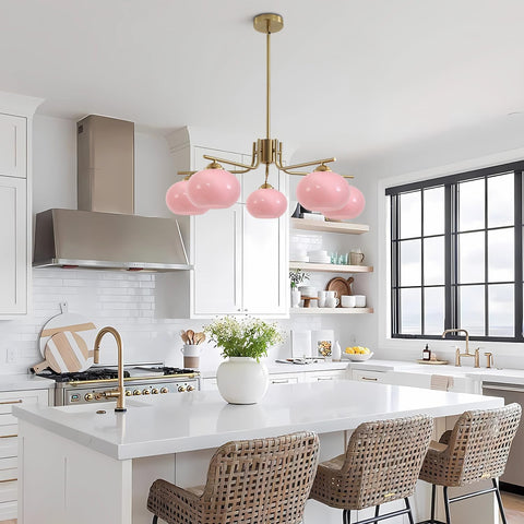 Modern kitchen with pink pendant light, white countertops, and wicker chairs.