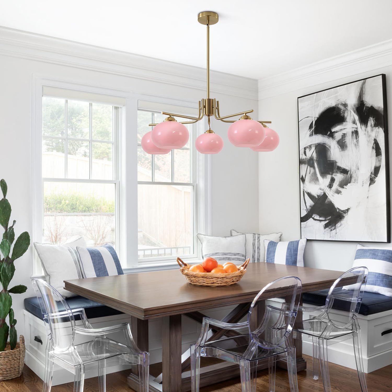 Dining room with pink pendant lights, wooden table, and clear chairs.