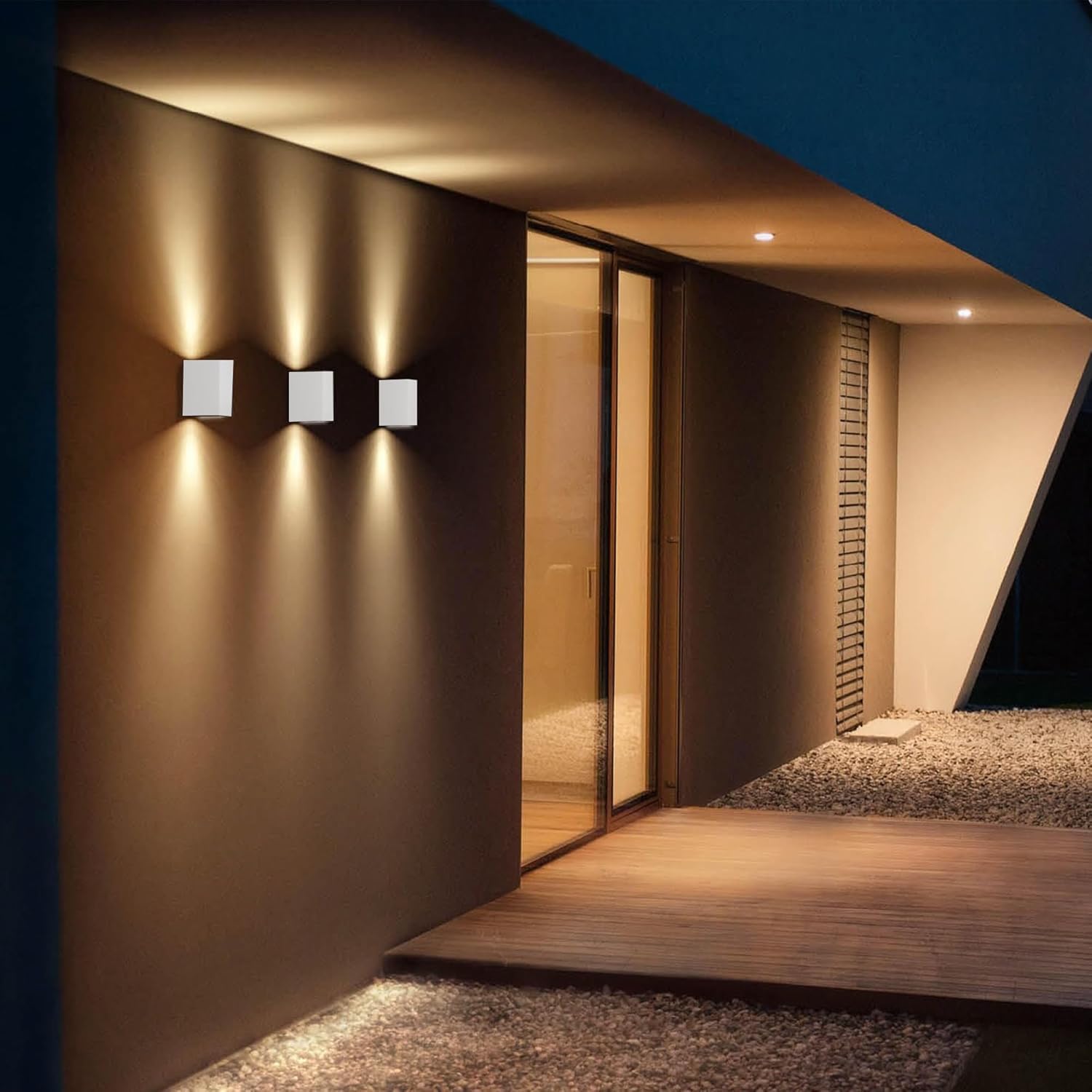 Modern architectural design with wall lights and glass doors at night.
