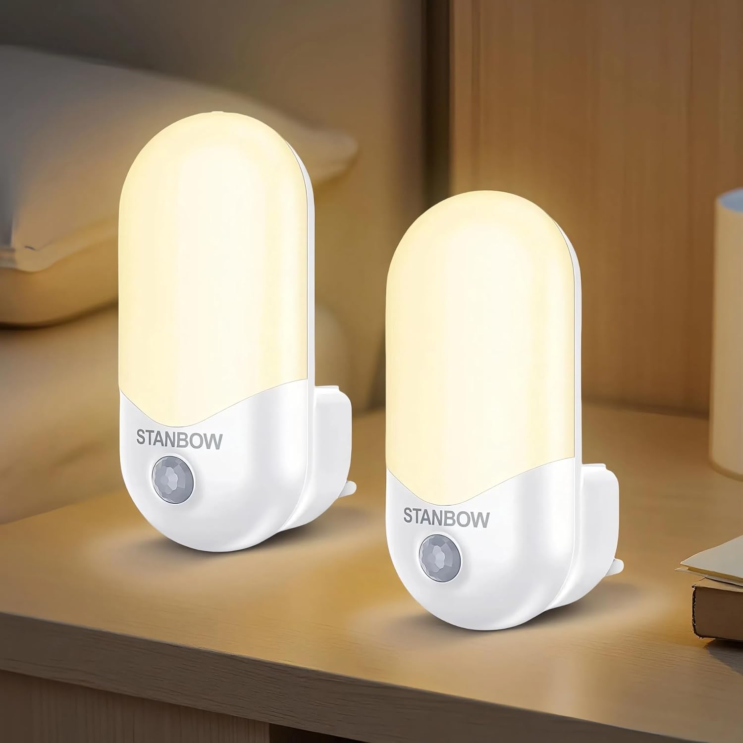 Two Stanbow night lights on a wooden surface with a blurred background