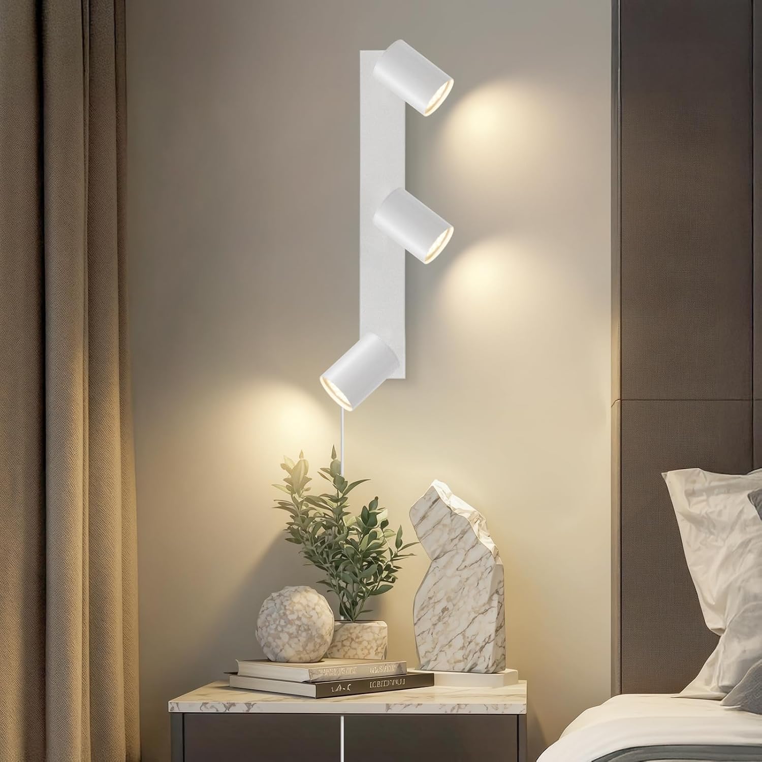 Modern wall light fixture on a neutral wall with decorative items on a nightstand.