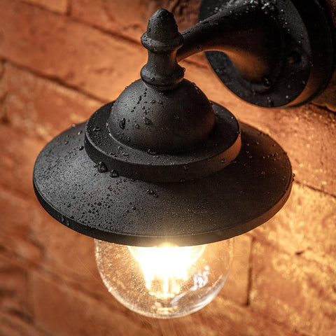 Vintage-style outdoor light fixture with a brick wall background