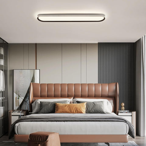 Modern bedroom with a brown leather headboard and gray bedding.